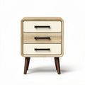 Wooden nightstand with three drawers and black handles in natural finish